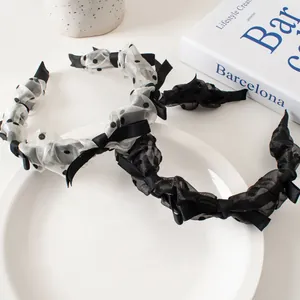 Close-up of pleated mesh headbands with black polka dots and satin bows detail
