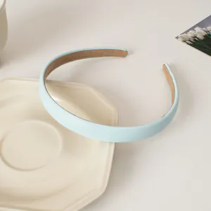 Détail d'un serre-tête en cuir bleu ciel avec doublure en velours marron sur céramique