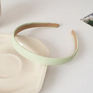 Détail du serre-tête en cuir PU vert clair avec doublure velours sur plateau céramique