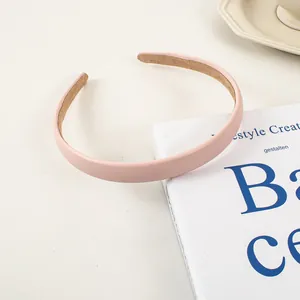 Détail d'un serre-tête en cuir rose mat sur un livre avec couche intérieure antiglisse