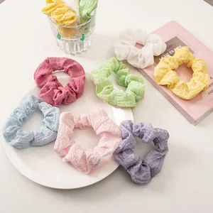 Macro shot of colorful seersucker scrunchies with pleated texture in assorted pastel tones