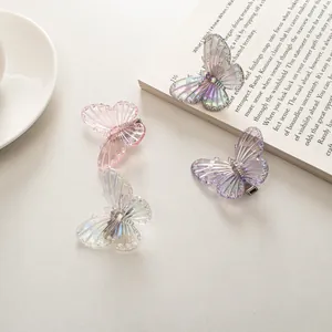 Fermagli per capelli a farfalla iridescenti in colori pastello su tavolo elegante