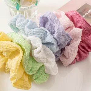 Detailed texture of colorful seersucker scrunchies in various candy colors for hair styling