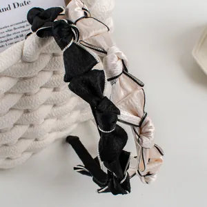 Elegant French vintage satin bow headbands in black and beige with metallic stitching