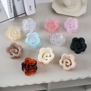 Pinces à cheveux en forme de fleurs mates et brillantes sur une table blanche