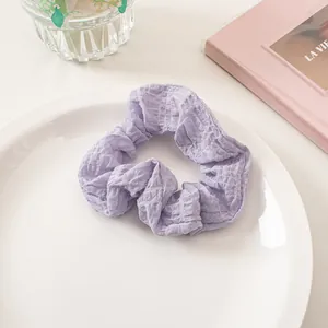 Close-up of lavender seersucker scrunchie texture and pleated fabric in a ceramic tray