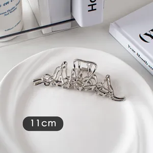 Gros plan d'une pince à cheveux argentée de 11cm avec texture ondulée métallique