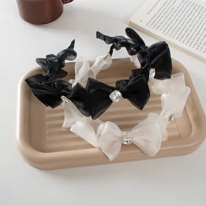 Detailed shot of mesh bow headbands with crystal accents in cream and black colors