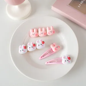 Vue détaillée des mignonnes pinces à cheveux lapin en résine rose et blanc avec fraises
