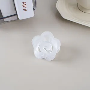 Gros plan détaillé d'une pince à cheveux en forme de fleur blanche givrée sur un bureau