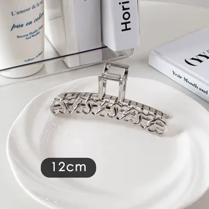 Détail d'une grande pince à cheveux en métal argenté de 12 cm avec motifs de cœurs