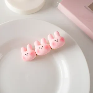 Détail d'une barrette à cheveux lapin rose en résine avec base en métal doré chic