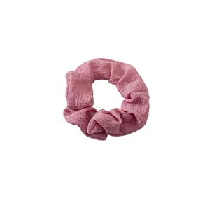 Soft pink seersucker scrunchie hair tie with ruffled texture for hair styling