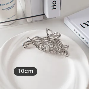 Détail macro d'une pince à cheveux papillon en métal liquide argenté de 10cm poli
