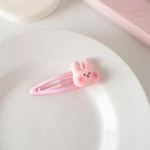 Détail d'une pince à cheveux lapin rose sur une assiette en céramique, style doux