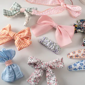 Dettaglio di fermagli per capelli e scrunchie a fiori e a quadretti per bambine