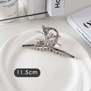 Détail macro d'une pince à cheveux papillon argentée de 11,5 cm en métal poli