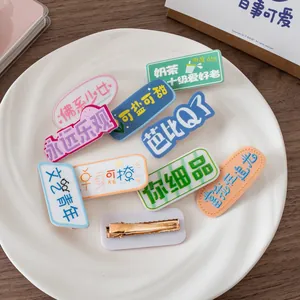 Barrettes colorées en acrylique avec motifs de texte drôles dans un plateau blanc