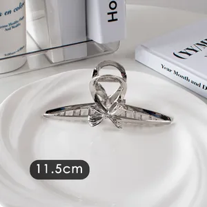 Vue détaillée de la pince à cheveux argentée en métal avec un nœud de 11,5 cm