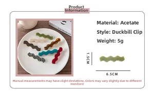 Close-up of wavy acetate hair clips in various colors including tortoiseshell and green