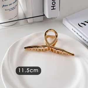 Détail montrant la longueur de 11,5 cm de cette grande pince à cheveux en métal doré brillant