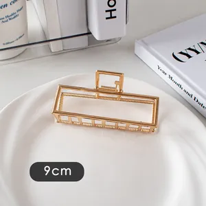 Détail d'une pince à cheveux rectangulaire de 9cm en métal creux au fini doré clair