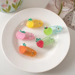Five pieces of cute fruit-shaped acrylic hair clips with glitter in a white ceramic tray