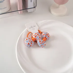 Dettaglio di elastici per capelli con fiocchi floreali in cotone su cartoncino