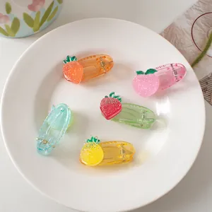 Close-up of cute fruit-themed resin hair clips with strawberry and pineapple shapes