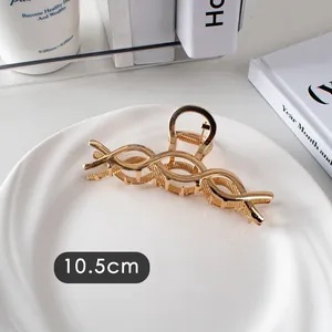 Détail de la pince à cheveux dorée de 10,5 cm avec un design torsadé minimaliste