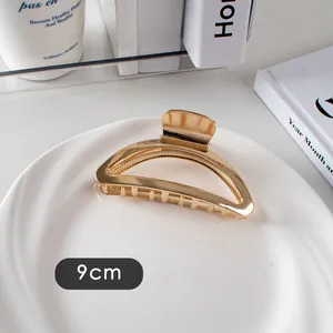 Vue détaillée d'une pince à cheveux de 9 cm en métal doré avec une finition miroir polie
