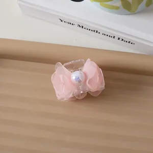 Detailed view of pink mesh bow hair claw clip with a large pearl accent and small design