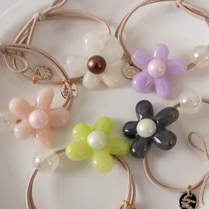 Cinq chouchous fleurs en résine aux couleurs gelée avec perles sur plat céramique