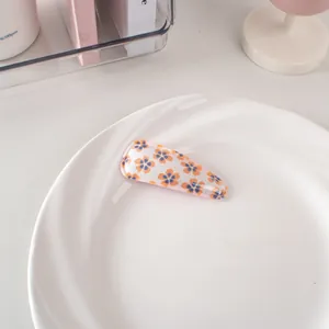 Vista dettagliata della clip per capelli BB a fiori su un piatto decorativo bianco