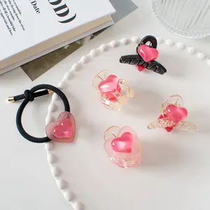 Détail de pinces à cheveux coeur rose et élastique sur un plateau blanc élégant