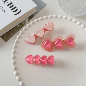 Vue détaillée du lot de barrettes à cheveux en forme de cœur rose gelée et acrylique