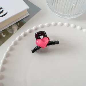 Détail de la pince à cheveux en forme de cœur avec cœur rose sur base noire