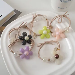 Détail des élastiques à cheveux fleurs avec perles en acrylique et finitions nacrées