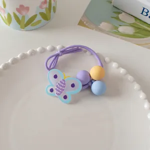 Detail of sweet floral hair tie with blue butterfly charm and pastel matte beads