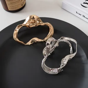 Set di fermagli per capelli in metallo a onde in oro e argento su piatto decorativo