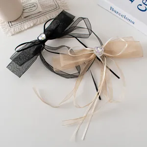 Détail du nœud élégant en organza avec cristal en forme de cœur sur fond blanc épuré