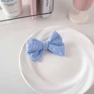 Vista dettagliata di un fermaglio per capelli a fiocco a quadretti blu e bianchi su piatto