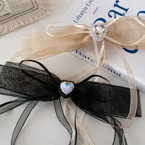 Barrette nœud élégante avec cristal de cœur et longs rubans en champagne et noir