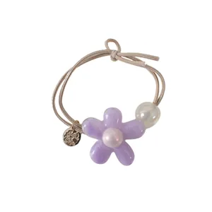Élastique à cheveux fleur couleur gelée avec perles et breloque en métal sur fond blanc pur