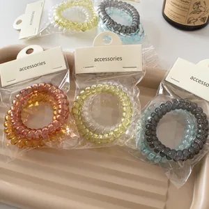Colorful spiral phone cord hair ties set in premium packaging on a beige tray