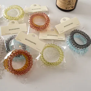 Close-up of spiral hair ties in assorted colors with paper cards and protective bags