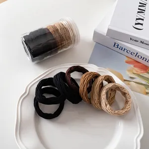 Detailansicht von elastischen Haarbändern in Erdtönen auf einem Keramiktablett