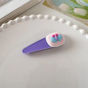 Detailopname van een paarse haarspeld met blauwe vlinder op een parelachtig dienblad
