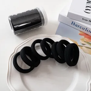 Makro-Detail von nahtlosen schwarzen Haargummis in einem klaren Kunststoffbehälter
