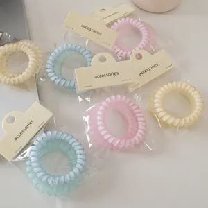 Detalle de gomas de pelo en espiral color macaron con embalaje individual